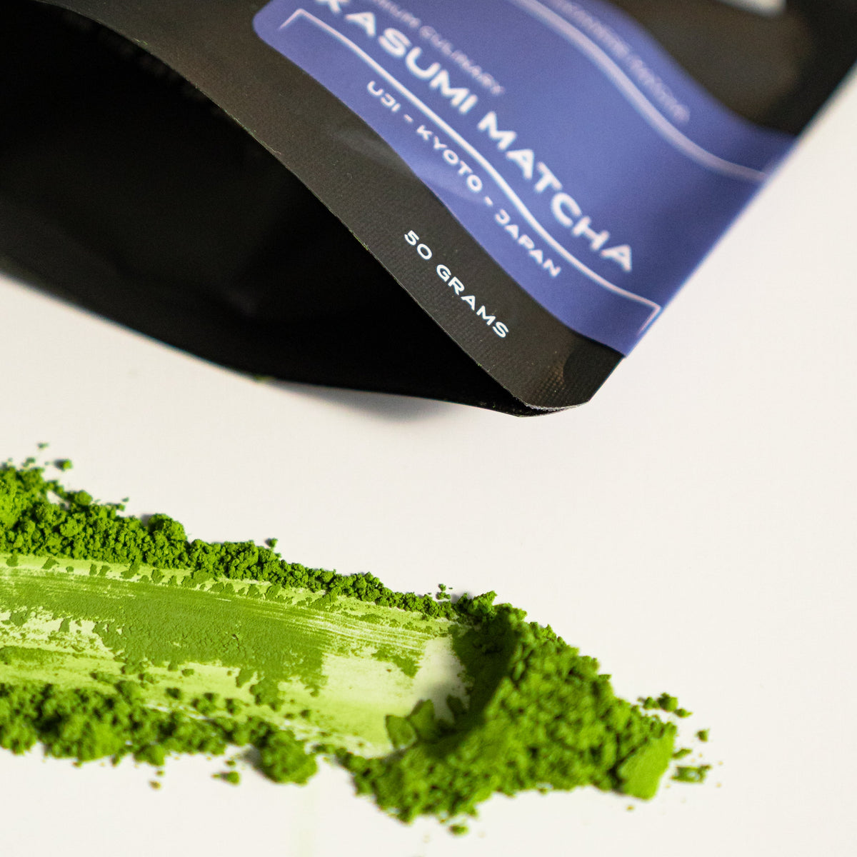 Kasumi Matcha container with green matcha powder on a white background